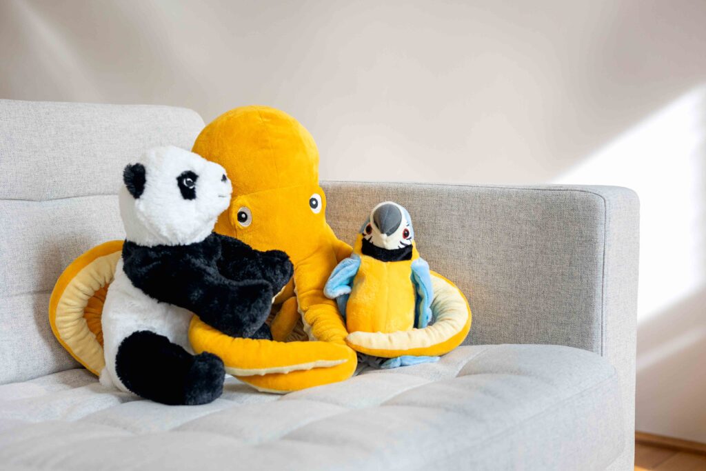 Zeigt Stofftiere auf der Therapiecouch